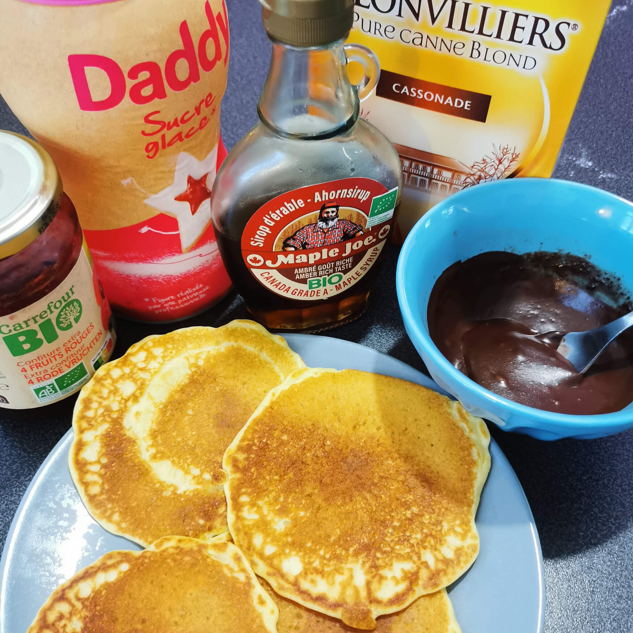 repas pancakes. pancake party avec sucre glace, sirop d'érable, chocolat fondu, confiture
